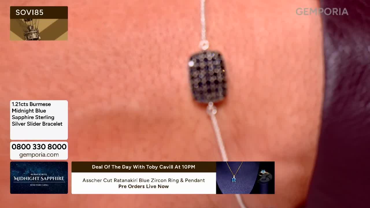 A thin silver chain holds a rectangular charm encrusted with tiny dark stones. The charm slides along the chain, resting against skin.