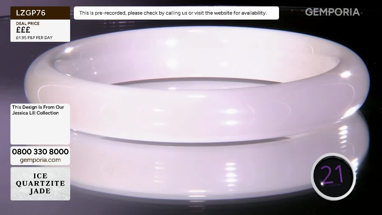 A smooth, white bangle sits on a reflective surface, catching the light. The Gemporia logo appears in the corner, indicating a television shopping channel presentation.