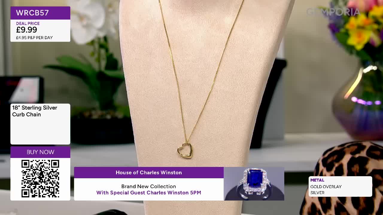 A delicate gold chain necklace with an open heart pendant rests on a display. On the screen, a sapphire ring with a halo of diamonds is showcased, ready for purchase. A delicate gold chain necklace with an open heart pendant rests on a display. On the screen, a sapphire ring with a halo of diamonds is showcased, ready for purchase.