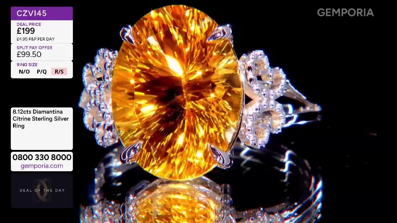 A large, oval citrine stone, set in silver, catches the light. Tiny diamonds sparkle on either side of the central gem, reflecting its warm glow. A large, oval citrine stone, set in silver, catches the light. Tiny diamonds sparkle on either side of the central gem, reflecting its warm glow.