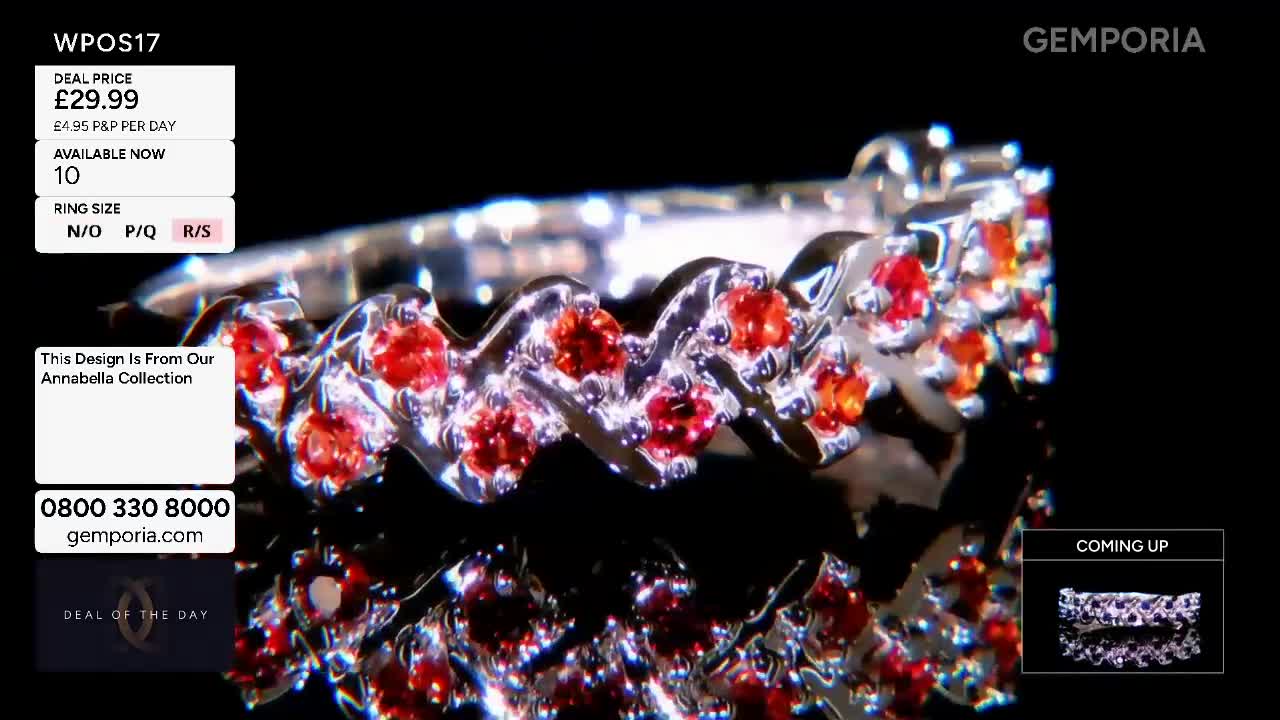 A silver ring, set with small red stones, rotates slowly. The Gemporia logo appears in the top right corner. A silver ring, set with small red stones, rotates slowly. The Gemporia logo appears in the top right corner.