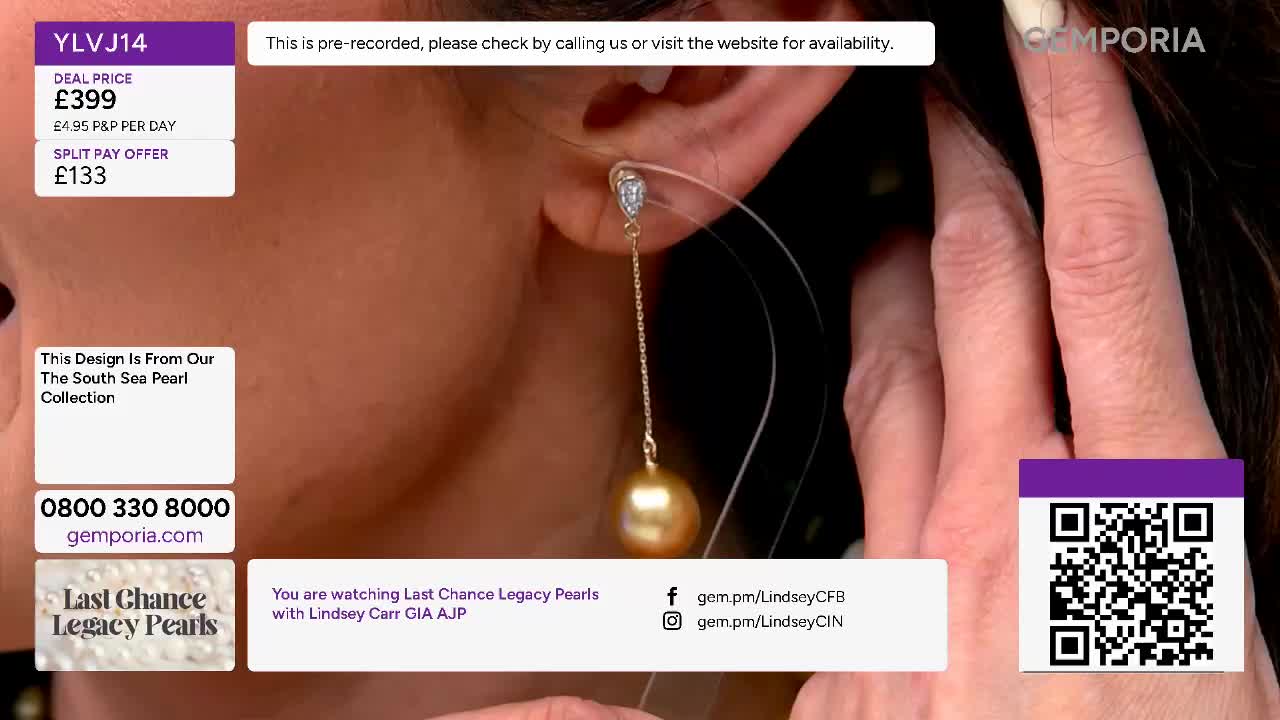 A delicate gold chain dangles a large, lustrous golden pearl from an earlobe. Fingers adjust the earring, showcasing its length and the pear's warm glow.