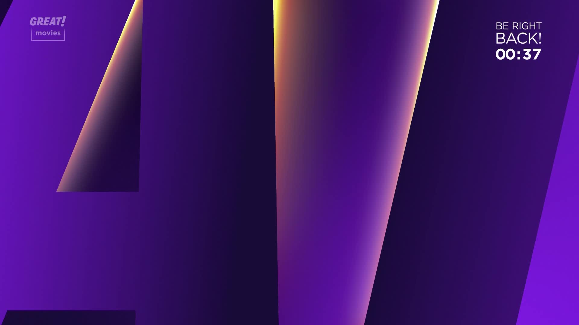 The GREAT! movies logo sits in the corner, and the screen is a gradient of purple with sharp, angled lines. A timer counts down, indicating a break is underway.
