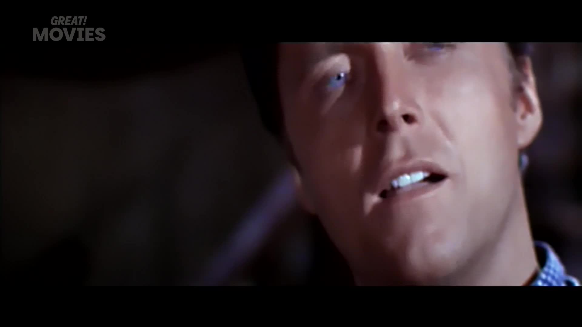 A man's face fills the frame, his eyes wide and his mouth slightly open. The "GREAT! MOVIES" logo appears in the top left corner.