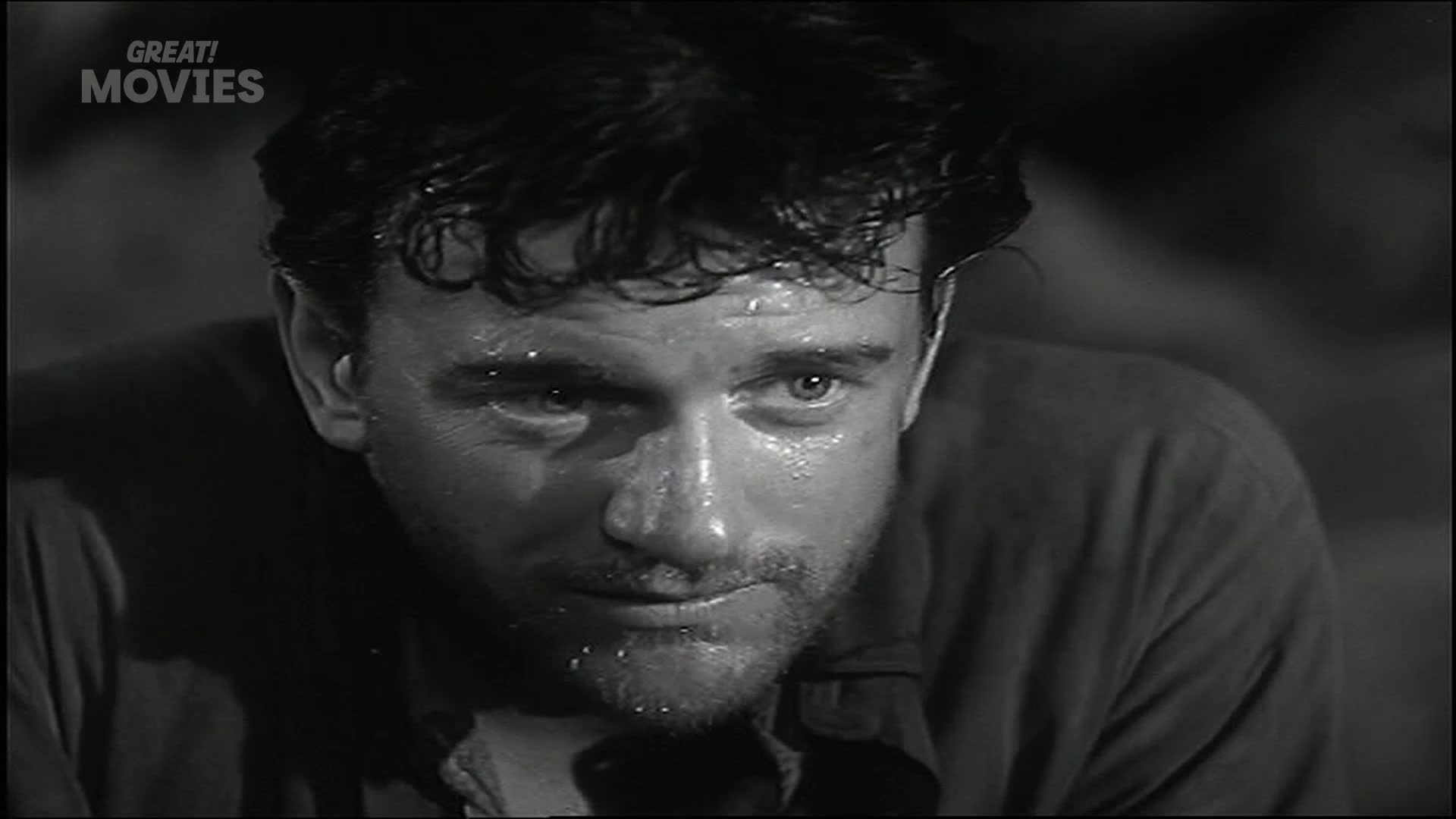 A man's face, slick with sweat, stares intensely forward. His dark hair is damp, clinging to his forehead.