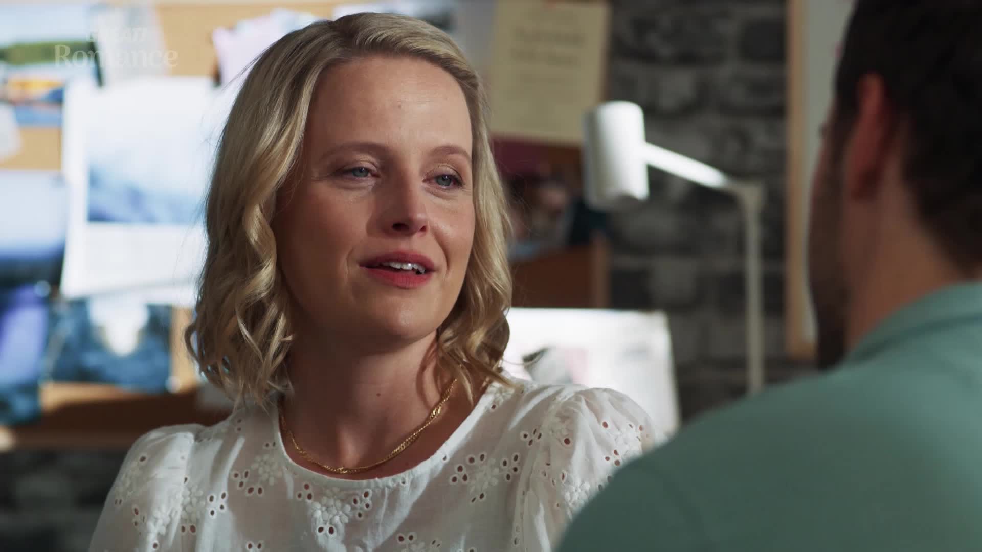 She's talking with a warm smile, her eyes bright. The background is a bit cluttered, like a busy office in the UK. She's talking with a warm smile, her eyes bright. The background is a bit cluttered, like a busy office in the UK.