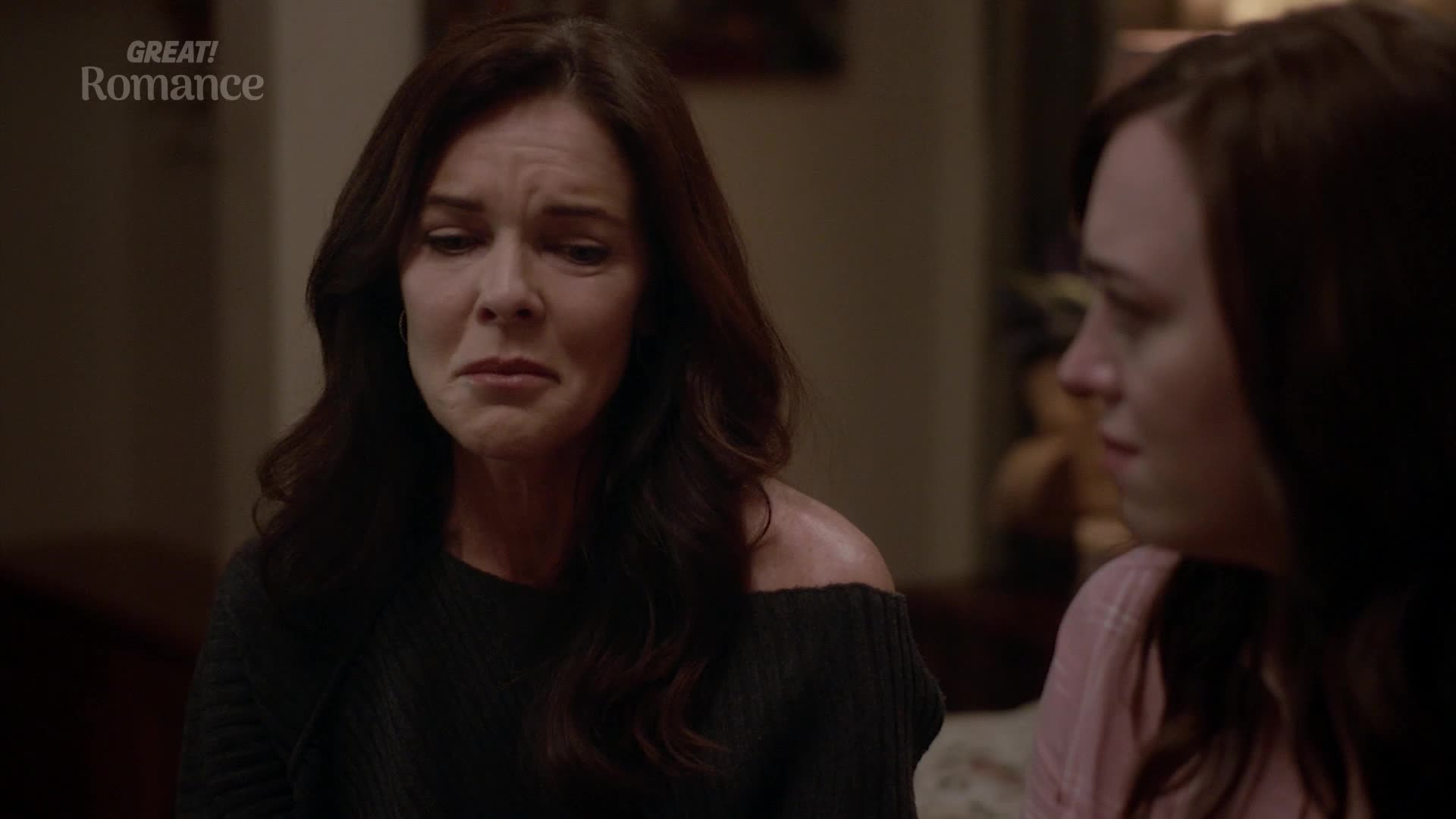 A woman with dark hair and a black off-the-shoulder top is crying, her face contorted with emotion. Beside her, a younger woman with brown hair looks on with a somber expression. A woman with dark hair and a black off-the-shoulder top is crying, her face contorted with emotion. Beside her, a younger woman with brown hair looks on with a somber expression.