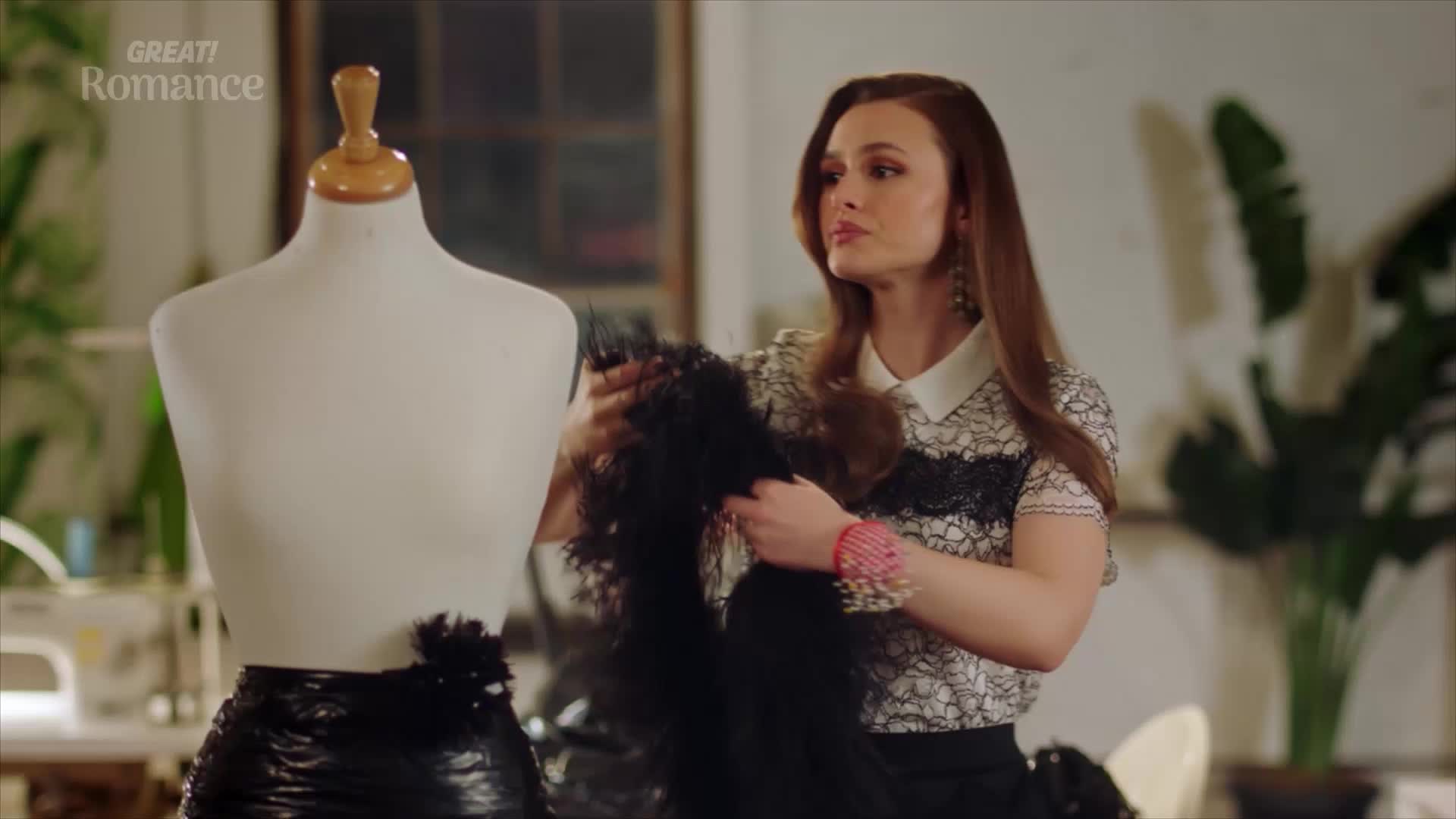 A young woman holds a length of black lace, her gaze focused on a mannequin. She's adjusting the fabric, her hands moving with purpose.