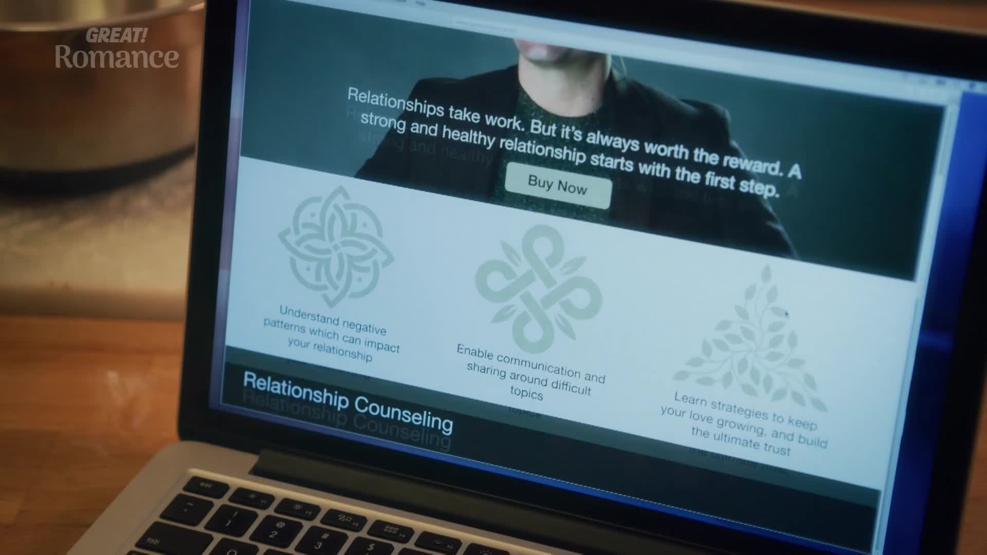 A laptop screen displays a website for "GREAT! Romance" relationship counseling. The page offers advice on understanding negative patterns, improving communication, and nurturing love.