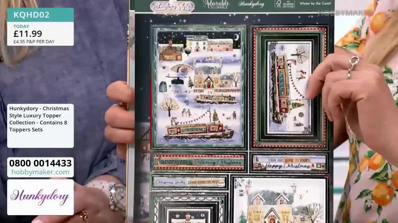 A woman's hand, adorned with a ring, points at a panel of Christmas-themed artwork. The panel, part of a Hobby Maker product, showcases winter scenes with canal boats and festive decorations.
