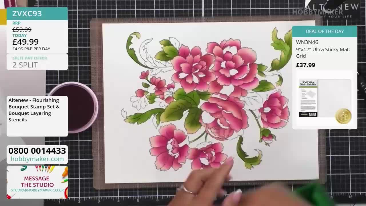 A hand is carefully coloring a detailed floral design on white paper. The Hobby Maker studio is showcasing the Altenew stamp set, with price details visible on the screen.
