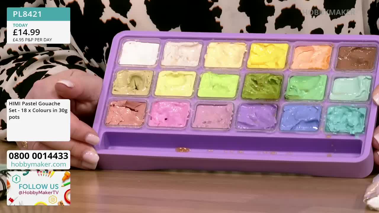 A person on Hobby Maker is holding up a tray of pastel gouache paints, each color in its own square. The colors range from white to brown, and the tray is purple.
