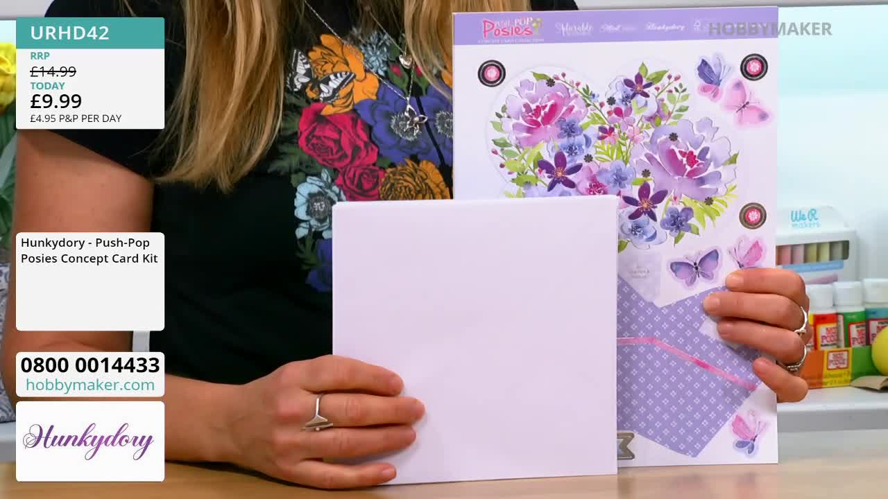 A woman holds a white card and a card kit featuring floral designs and butterflies. The Hobby Maker logo is visible on the packaging.
A woman holds a white card and a card kit featuring floral designs and butterflies. The Hobby Maker logo is visible on the packaging.
