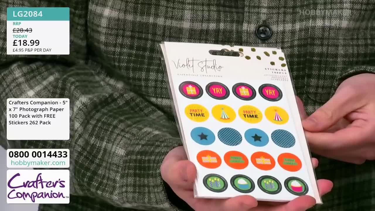 A person is holding a package of stickers from Violet Studio, showcasing the designs. The Hobby Maker logo is visible in the background, along with a price tag for the product.
