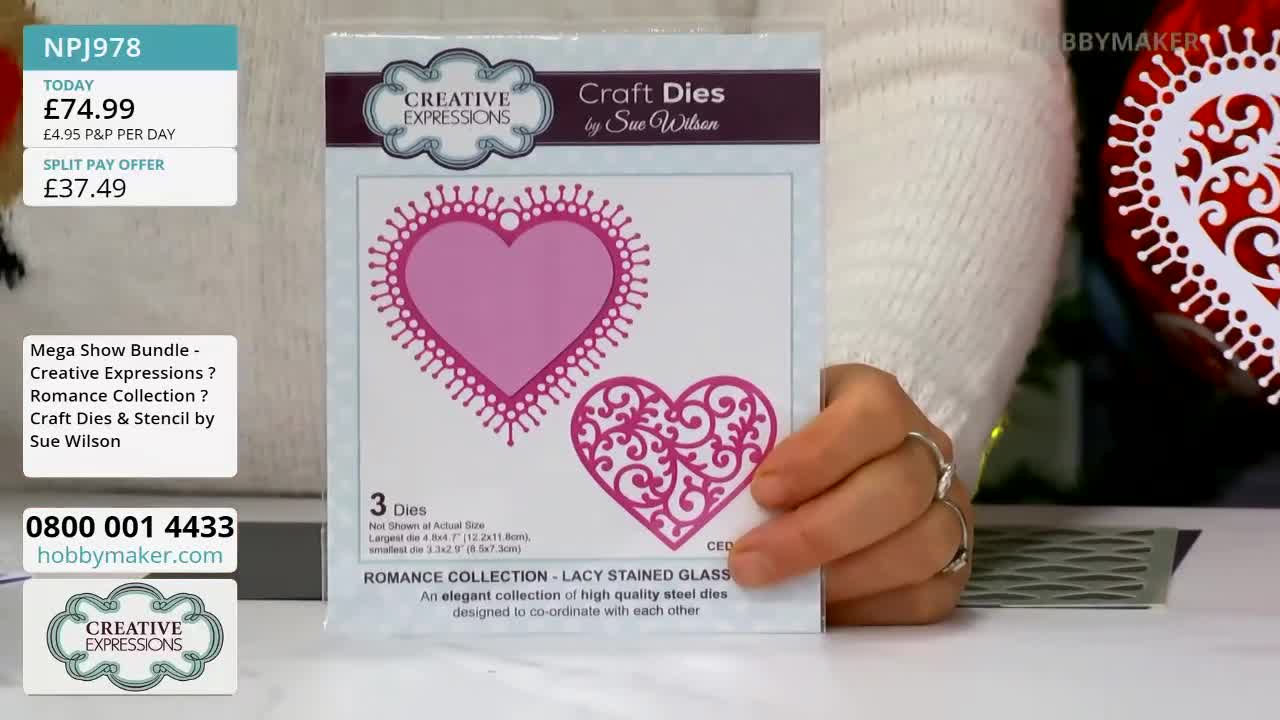 A woman's hands hold a card featuring pink heart-shaped craft dies from Hobby Maker. The card displays two hearts, one solid and one with a decorative, lacy pattern.
