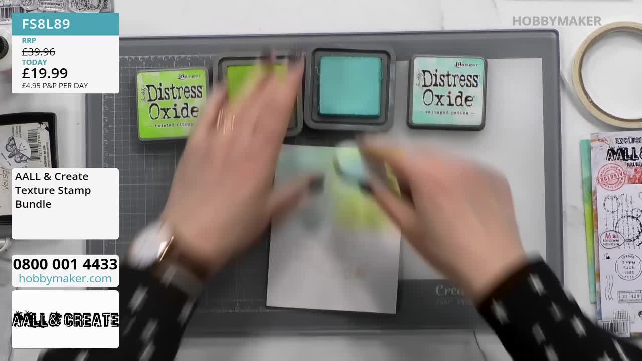 Hands are blending a light green ink onto a white card. Three "Distress Oxide" ink pads, one lime green, one teal, and another lime green, sit nearby on a cutting mat.