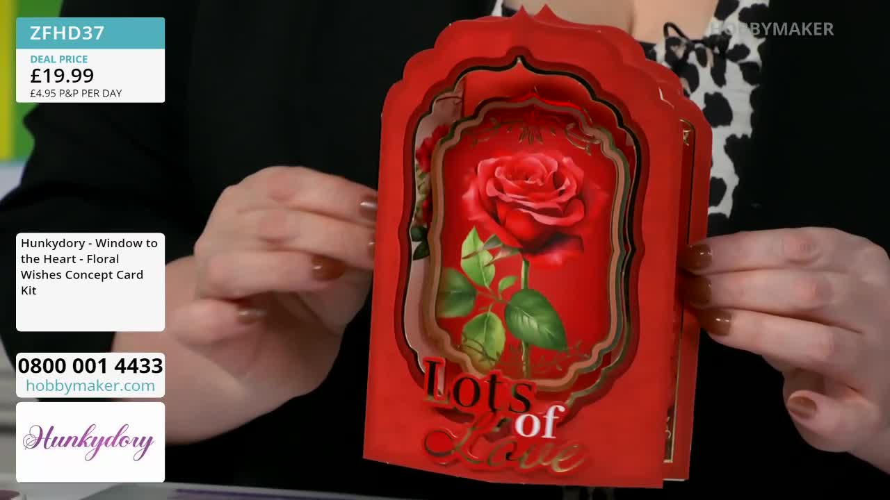 Fingers gently adjust the layers of a red card featuring a detailed rose and the words "Lots of Love." This card kit from HunkyDory is being presented by Hobby Maker.