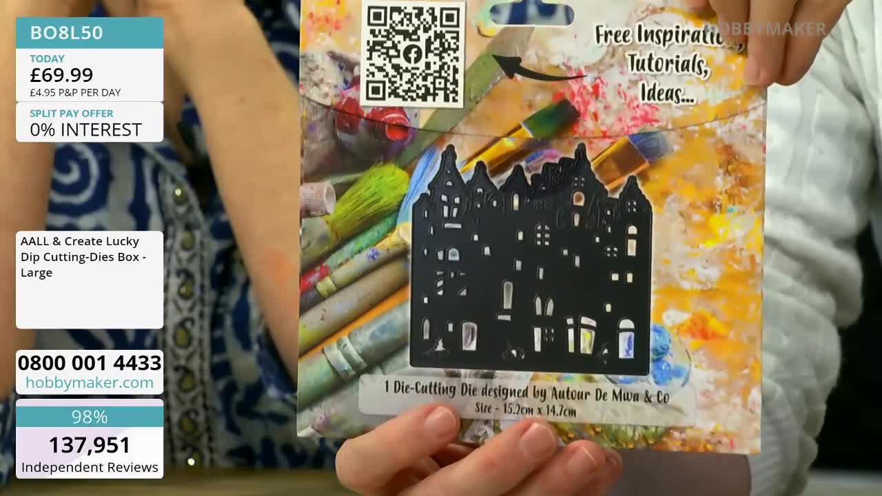 A hand holds up a black die-cutting stencil of a city skyline. The packaging behind it features art supplies and text promoting free inspiration.