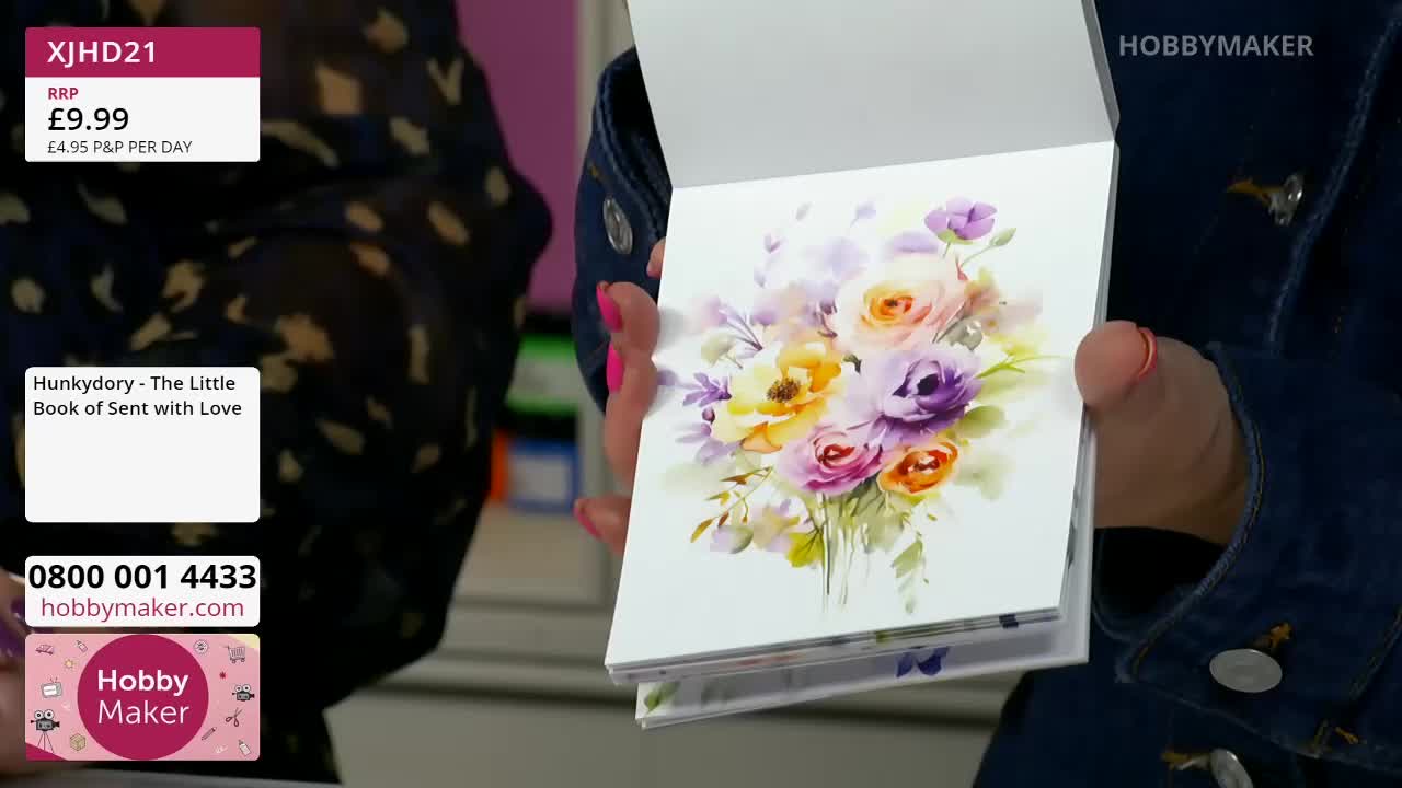 A woman's hands hold open a book of watercolour flowers. The pages reveal a delicate bouquet of roses in shades of pink, yellow, and purple.