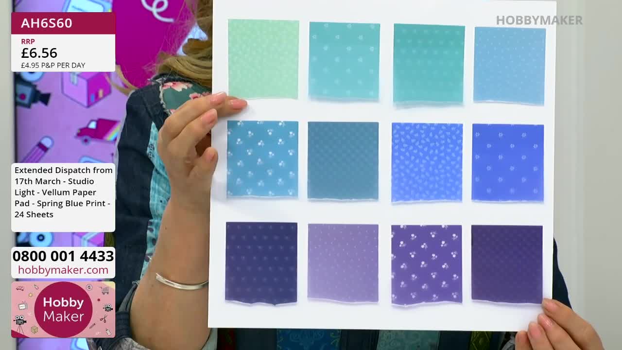 Fingers point to a sheet displaying twelve squares of patterned paper in shades of blue and purple. The Hobby Maker logo is visible on the left side of the display.