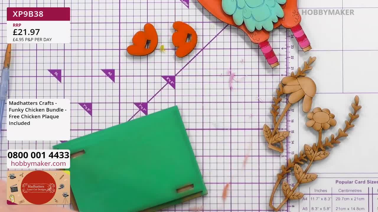 A bright green cardstock is being manipulated, its edges slotted into place. Nearby, a wooden craft kit with a whimsical chicken and floral elements lies ready for assembly. A bright green cardstock is being manipulated, its edges slotted into place. Nearby, a wooden craft kit with a whimsical chicken and floral elements lies ready for assembly.