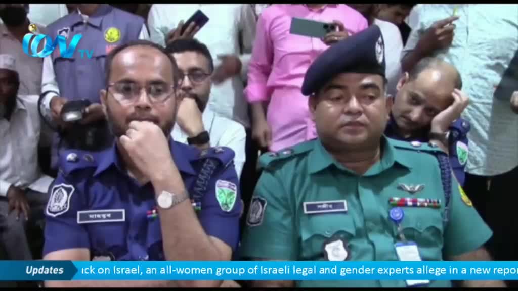 Two uniformed men sit close together, the one on the left in blue, the other in green. The man in blue rests his chin on his hand, while the man in green looks directly at the camera, a beret on his head.
