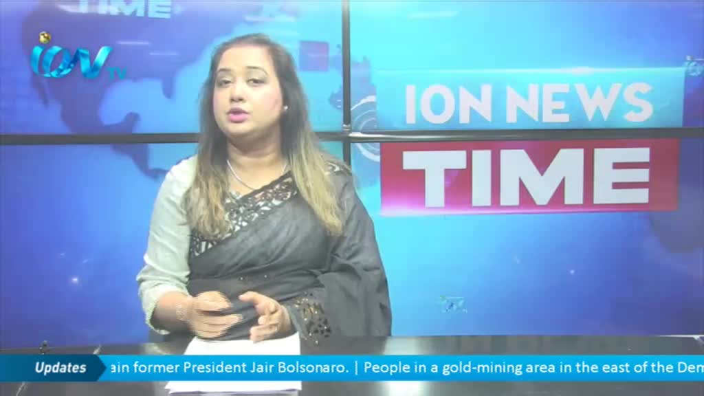 A woman in a black and gray patterned top is speaking, gesturing slightly with her hands. The backdrop includes the ION News logo and the word "TIME" on what looks like a television screen.
