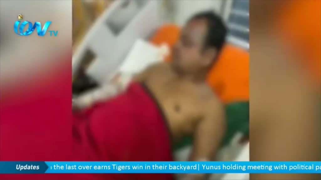 A man lies in a bed, covered by a red blanket, as seen on Ion TV. The news ticker at the bottom of the screen mentions a sports victory and a political meeting.
