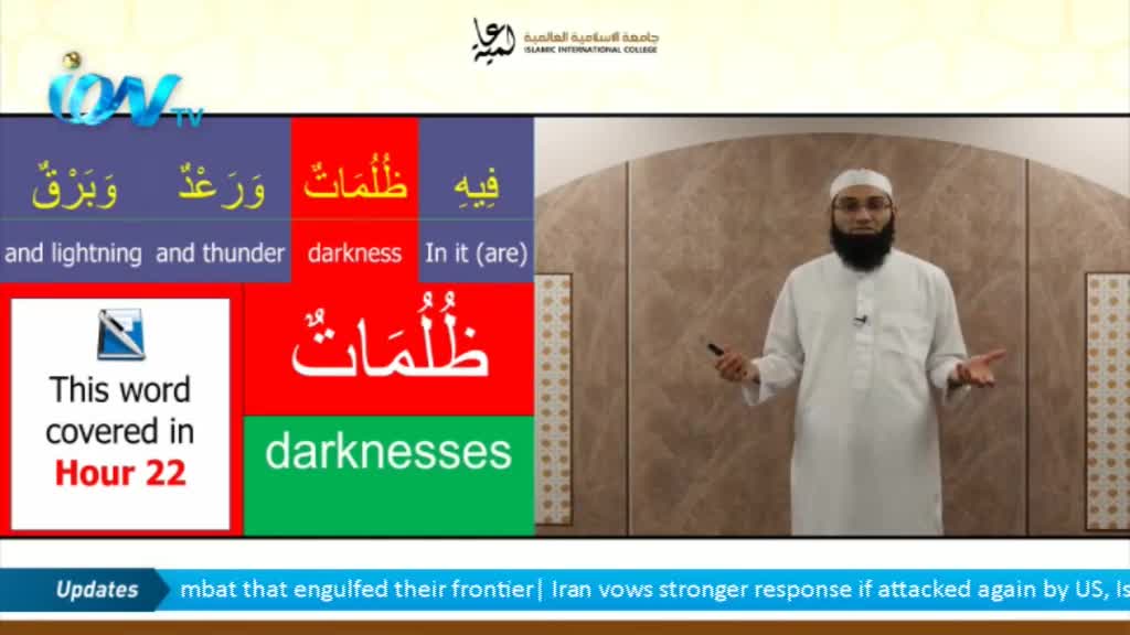 A man in a white robe gestures with his hands as he speaks, a small microphone clipped to his chest. On the screen, colorful blocks display Arabic words and their English translations, all part of a lesson on Ion TV.
