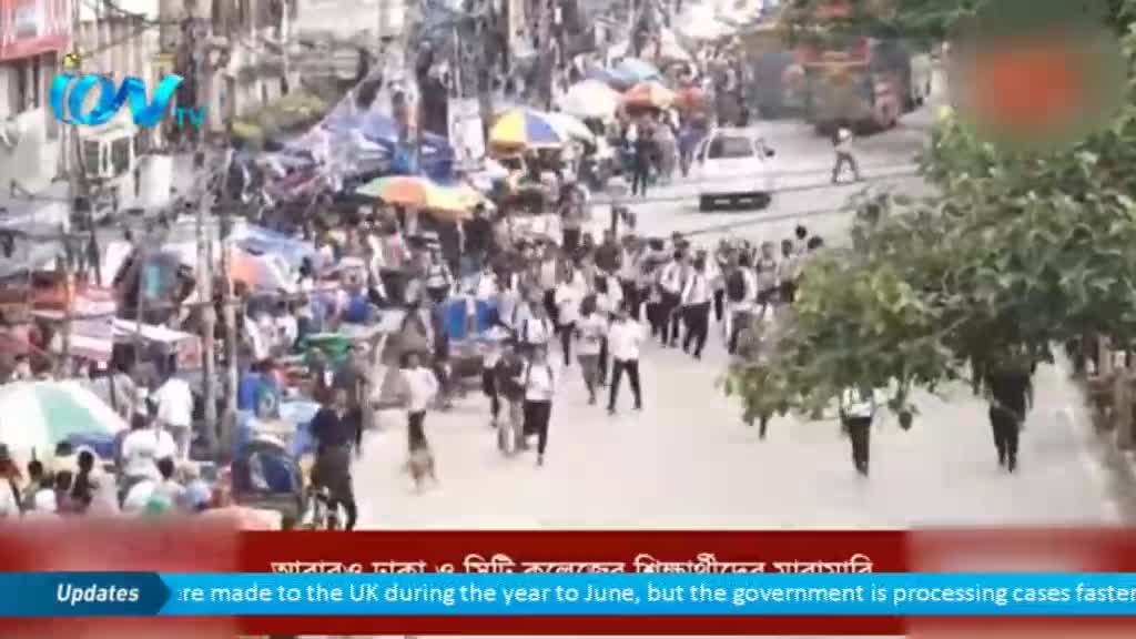 A dense crowd moves down a street, some with umbrellas, while a white car drives through. The Ion TV logo sits in the corner as a news ticker runs along the bottom.
