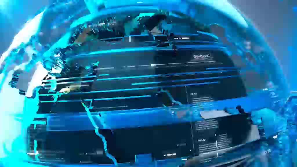 A digital globe, rendered in shades of blue, spins rapidly. Text and data streams appear across the surface as if it's a news broadcast from the United Kingdom, possibly on Ion TV.
