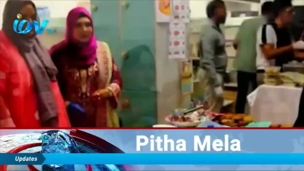 Two women in headscarves stand near a table laden with food, likely at a festival. A news graphic for Ion TV displays "Pitha Mela" at the bottom of the screen.
