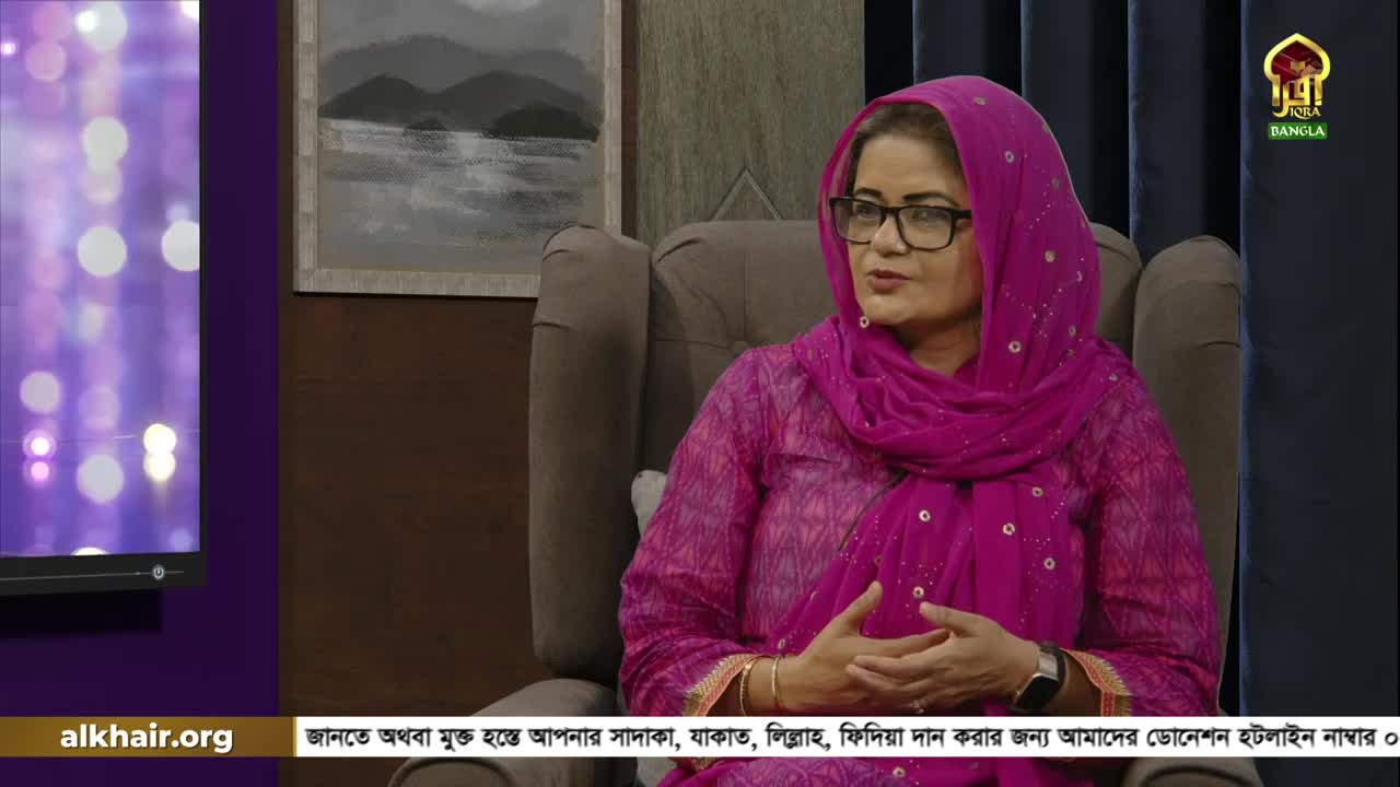 A woman in a pink headscarf and glasses sits in a chair, speaking into a microphone. The Iqra TV Bangla logo and a website address are visible in the corner.
