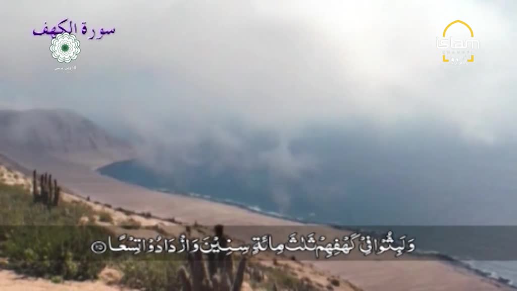 The coastline stretches out beneath a cloudy sky, with a broadcast from Islam Channel Urdu in the corner.  Arabic script and a scenic view are displayed, likely part of a religious program.
