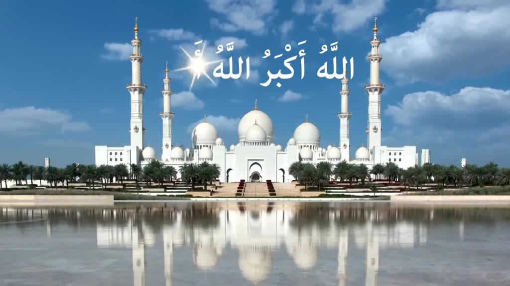 A grand white mosque, its minarets reaching towards a bright blue sky, is reflected in the still water below. Above the mosque, in elegant Arabic script, the words "Allah is the greatest" are displayed.
