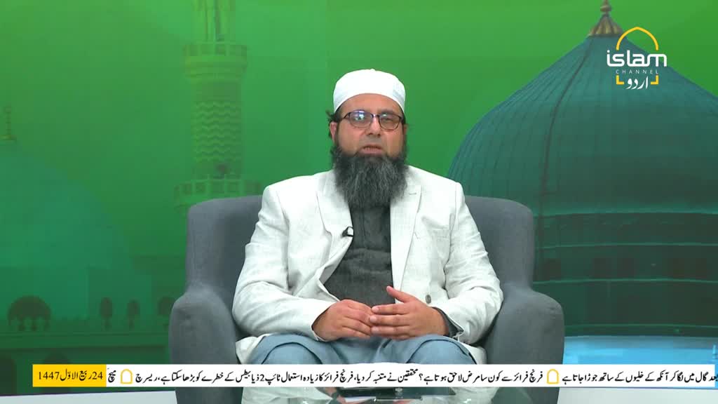 A man in a white jacket and a white cap sits in a chair, speaking on a green-screen set for Islam Channel Urdu. The Urdu logo is visible in the upper right corner.
