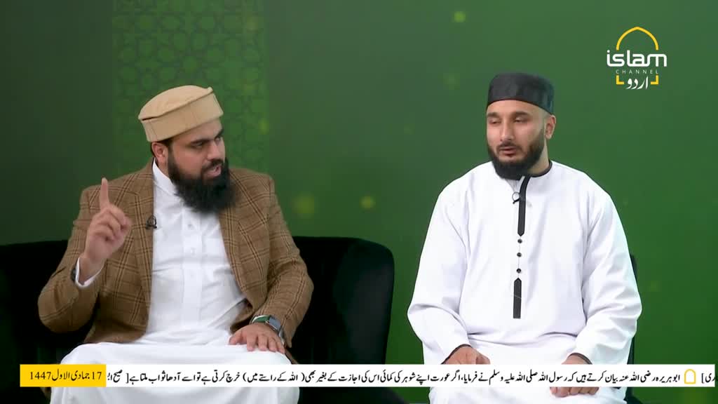 On the Islam Channel Urdu set, a man in a brown blazer gestures emphatically as he speaks. Beside him, another man in a white robe listens intently, a small black cap atop his head.
