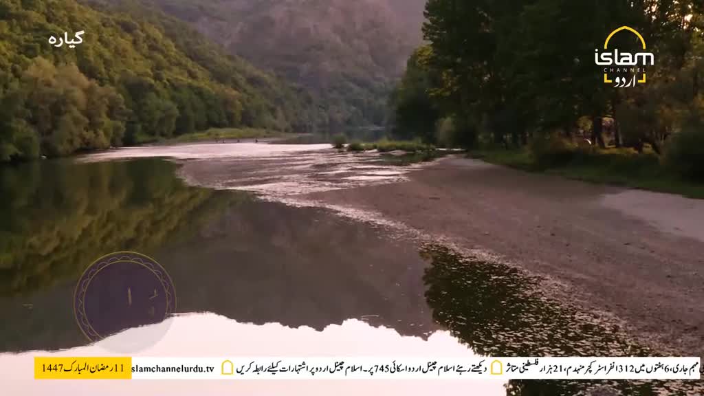 The river flows gently through a valley, its surface reflecting the surrounding trees and hills. A sandy bank lines the right side, dotted with fallen leaves. The river flows gently through a valley, its surface reflecting the surrounding trees and hills. A sandy bank lines the right side, dotted with fallen leaves.