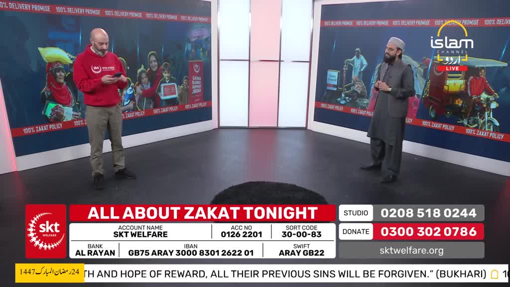 A man in a red hoodie stands with his phone, while another man in a grey shalwar kameez addresses the camera. Behind them, screens display images related to charity and the Islam Channel Urdu. A man in a red hoodie stands with his phone, while another man in a grey shalwar kameez addresses the camera. Behind them, screens display images related to charity and the Islam Channel Urdu.
