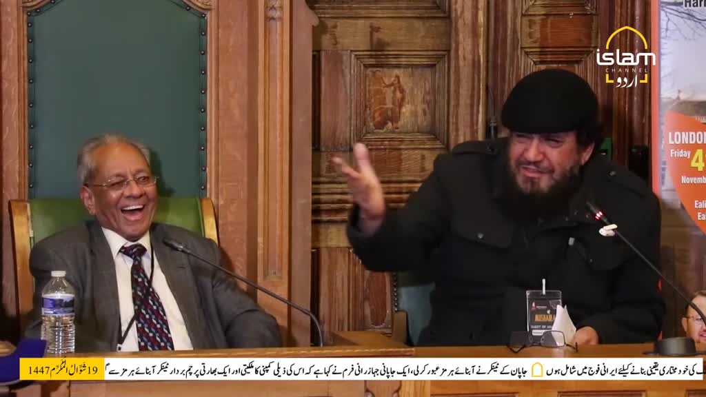 Two men are seated, one with his mouth wide open in laughter, the other gesturing with his hand. The Islam Channel Urdu logo is visible on a poster behind them.