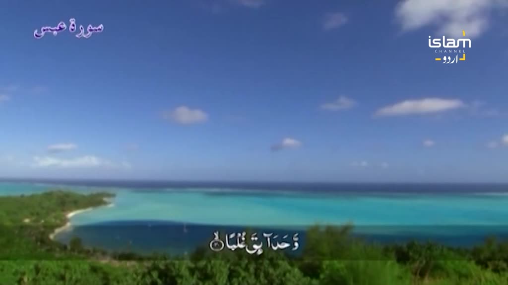The bright turquoise water laps against a lush green island under a clear blue sky. Arabic script, likely from Islam Channel Urdu, appears on screen.