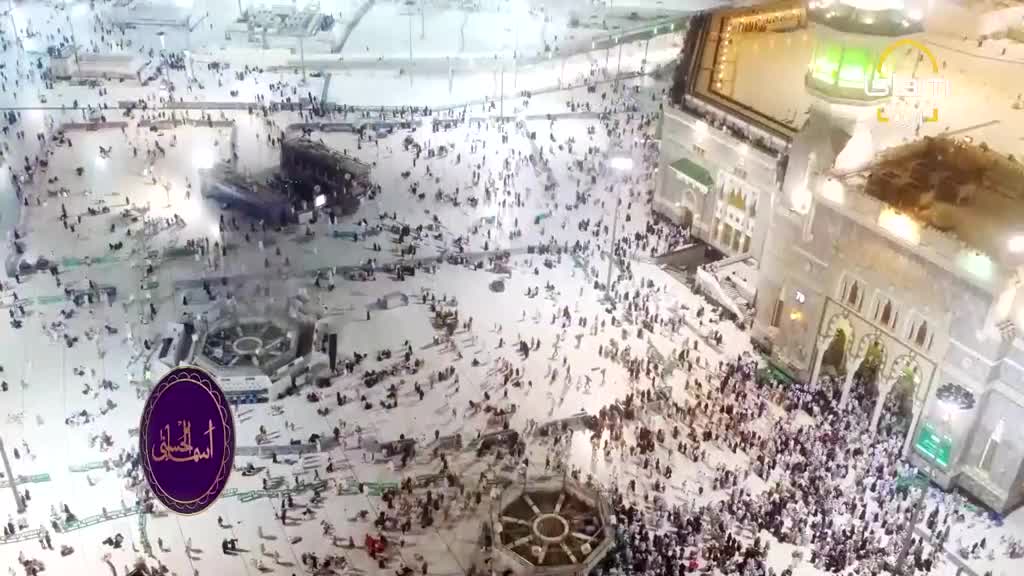 Thousands of people in white garments circle the Kaaba, a massive stone structure. A broadcast from Islam Channel Urdu is playing, showing this scene.