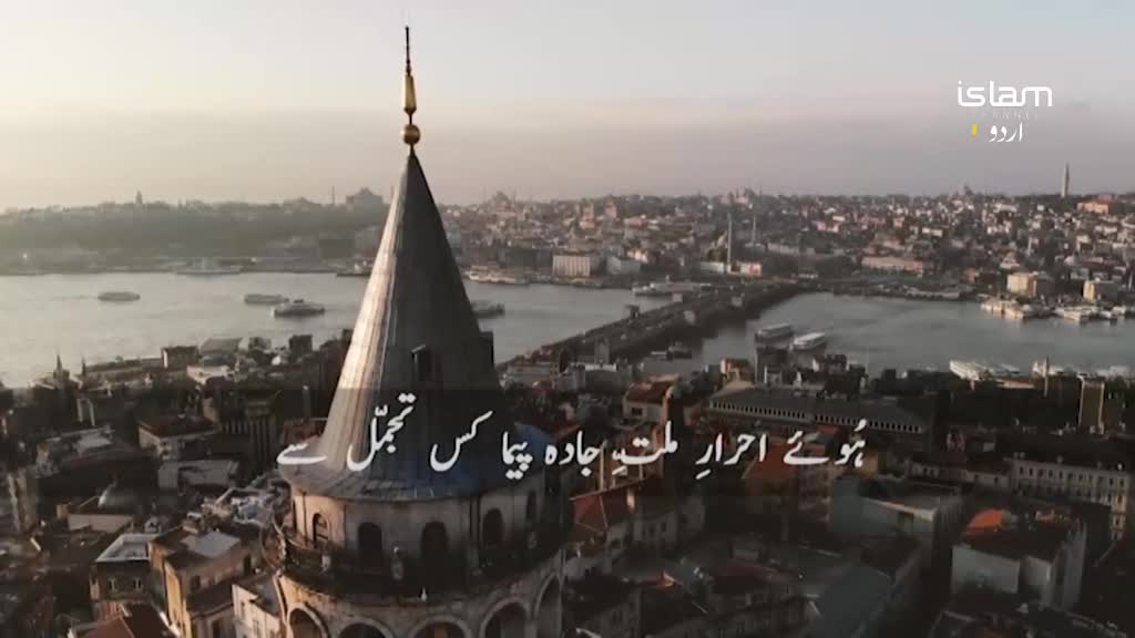 A conical tower, topped with a golden spire, dominates the foreground. Beyond it, a city sprawls towards a wide waterway dotted with ferries.