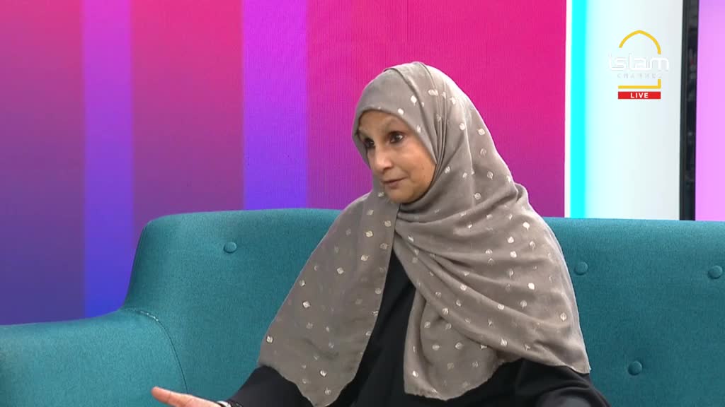 A woman in a patterned headscarf sits on a teal couch, speaking.  The background behind her is a gradient of pink and purple, and the Islam Channel logo is visible.
