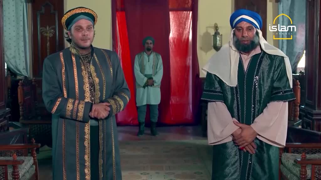 Two men in ornate robes and turbans stand facing the camera, while a third man in simpler attire stands further back. The logo for Islam Channel is visible in the corner.

