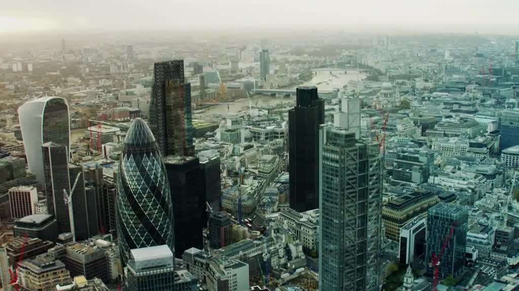 From this high vantage point, the city sprawls out, a sea of buildings under a hazy sky. The iconic Gherkin and other skyscrapers stand out against the backdrop of London's dense urban landscape.

