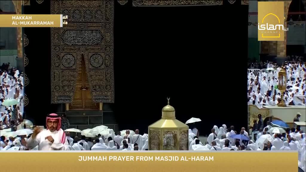 A man in traditional attire gestures while speaking, likely leading the Jumm'ah prayer. The scene is being broadcast live from Masjid Al-Haram, as shown on the Islam Channel.

