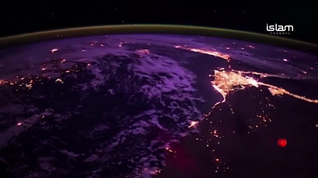The Earth, a swirling mass of purple and dark blue, is lit up by the glow of city lights. A red orb hovers below, and the Islam Channel logo is visible in the corner.

