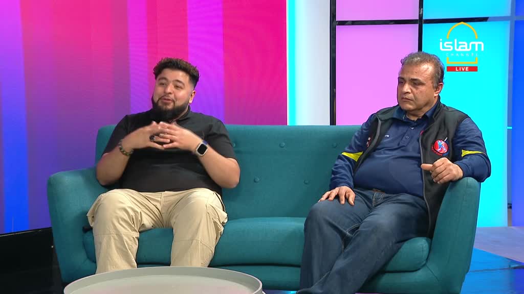 Two men sit on a teal couch, the one on the left gesturing with his hands while speaking. The backdrop is a gradient of pink and purple, and the Islam Channel logo is visible in the corner.
