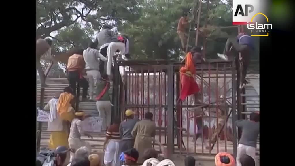 People are scrambling over a metal gate, some using the bars as a ladder. The scene is being covered by Islam Channel, with the AP logo visible.
People are scrambling over a metal gate, some using the bars as a ladder. The scene is being covered by Islam Channel, with the AP logo visible.